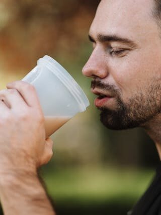 Un sportif qui boit un shaker de whey protéine