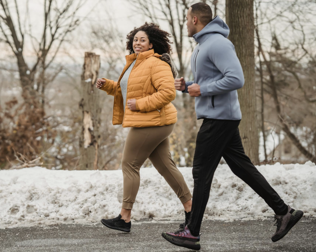 Hommes et femmes qui courent sous la neige en hiver